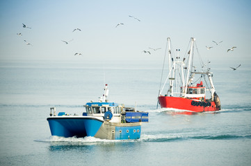 fishing trawlers returning to port on a hazy day