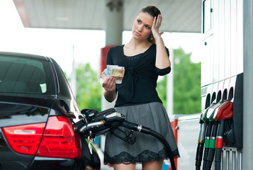 Fototapeta na wymiar woman counting money on gas station