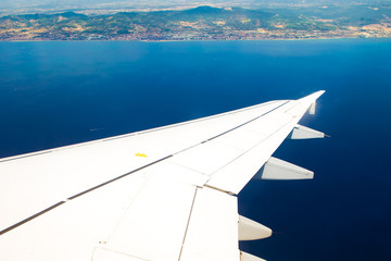 wing of airplane with view to the sea