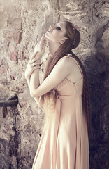 young blond woman posing on wall background