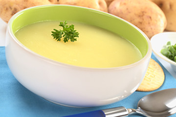 Fresh potato cream soup garnished with a parsley leaf