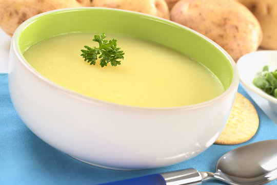 Fresh potato cream soup garnished with a parsley leaf