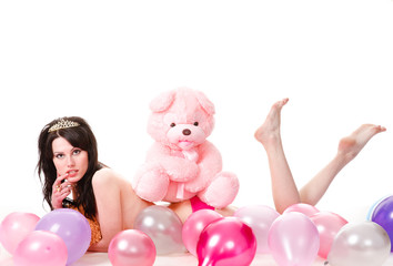 Young sexy woman is among the balloons, with a teddy bear.