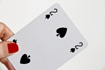 Mano di donna che tiene la carta del due di picche