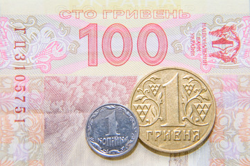one kopek and hrivna coins against one hundred bill