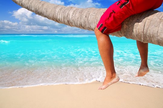 Caribbean inclined palm tree beach tourist legs