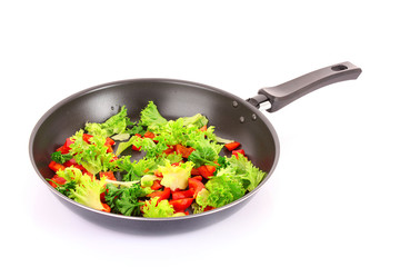 frying pan with vegetables  on white