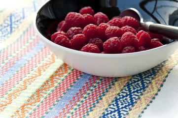 Fresh raspberries on colorful tablecloth