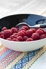 Fresh raspberries in black bowl