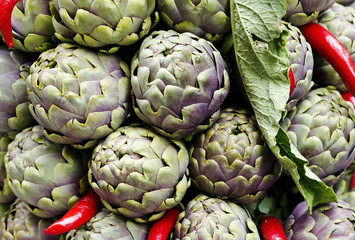 Fototapeta premium artichokes and red peppers on a market desk in rome