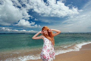 久高島の砂浜に立っている笑顔の女性
