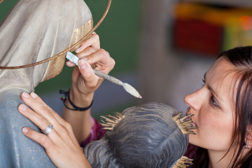 frau restauriert alte kichenfigur