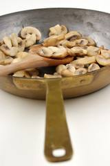 angebratene Champignons in einer Messingpfanne