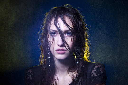 Fine art portrait of wet hair female under spots of rain.