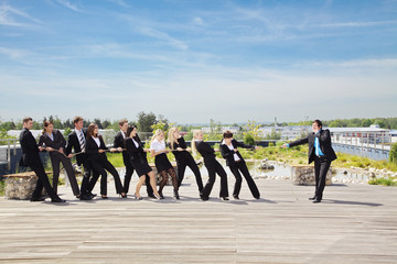 Obraz premium Jeden przeciwko wszystkim, przeciąganie liny między pracownikami, jeden ziewa