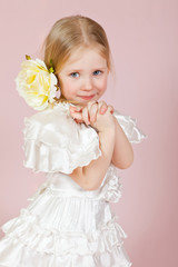 child in a white dress with a flower in hair