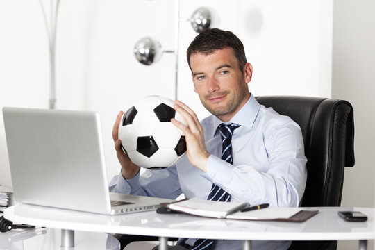 young businessman in office with computer and ball