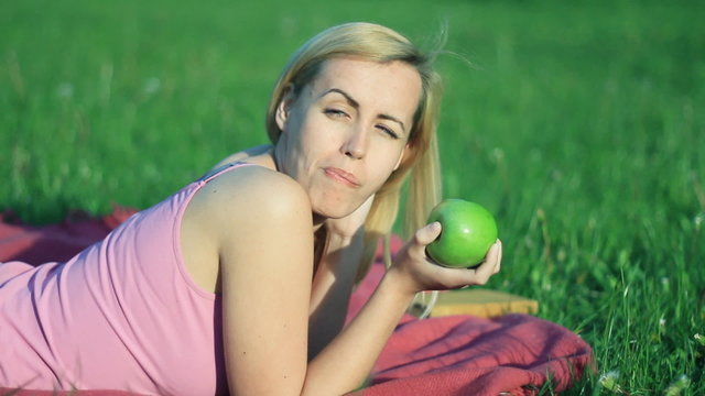Attractive happy woman biting fresh apple outdoor