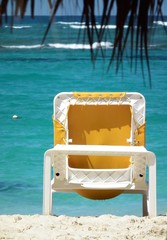 chaise longue sur plage sous une hutte