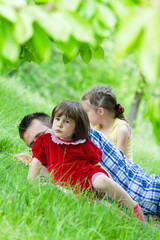 Father playing with two daughters in beautiful green grass