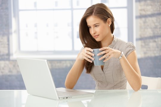 Businesswoman with laptop having tea