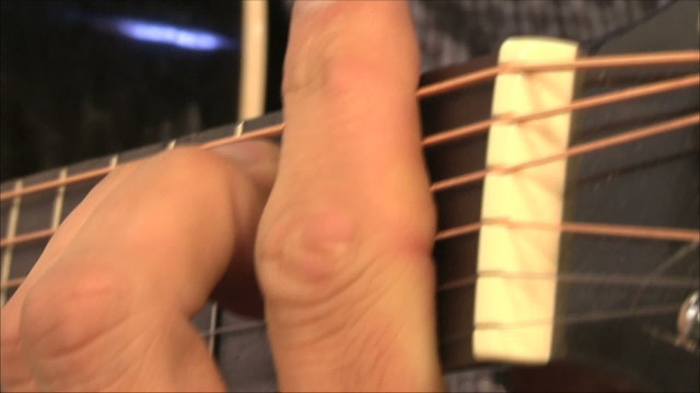 музыкант играет на гитаре, крупно пальцы
