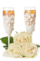 Two glasses of celebratory champagne with white roses