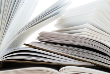 Pile of open books on white background