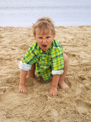 grimacing boy on the beach