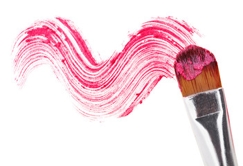 Pink lipstick stroke (sample) with makeup brush, isolated on whi
