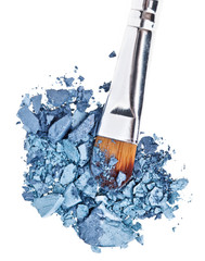 Makeup brush with grey blue crushed eye shadow, isolated on whit