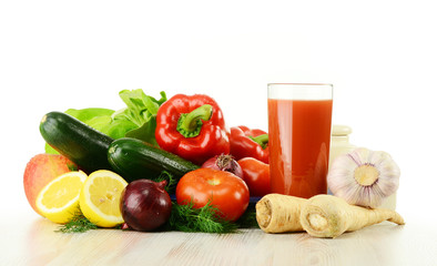 Raw vegetables and glass of juice isolated on white