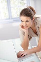 Naklejka premium Pretty girl using laptop at home