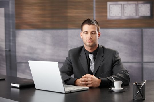 Top manager meditating in elegant office