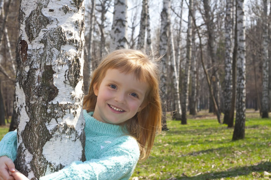Smiling girl in birch grove