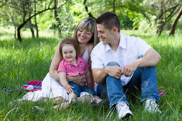 Naklejka na ściany i meble Young family of three on a picnic