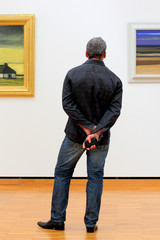 Homme de dos, observant un tableau