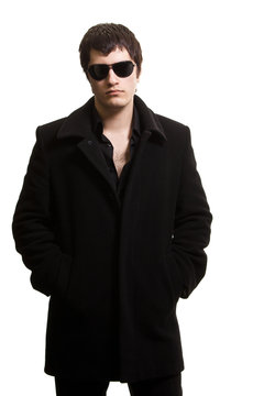 confidence man in black coat and sunglasses