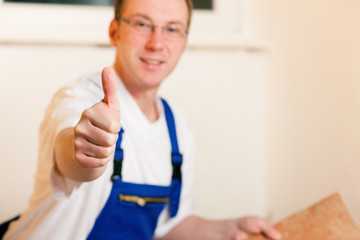 Obraz premium Fliesenleger auf der Baustelle