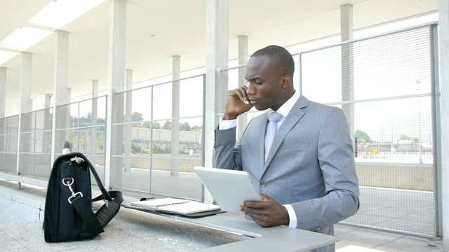 Businessman working with electronic tablet outside the office
