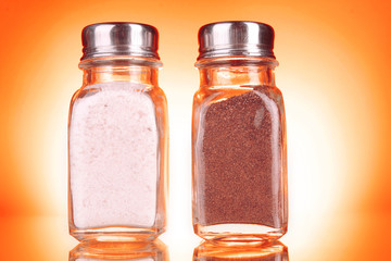 Glass salt and pepper shakers  on yellow background