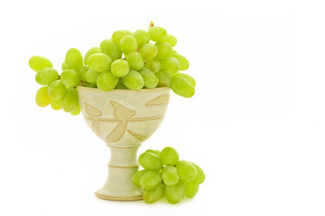ripe green grapes in pottery goblet