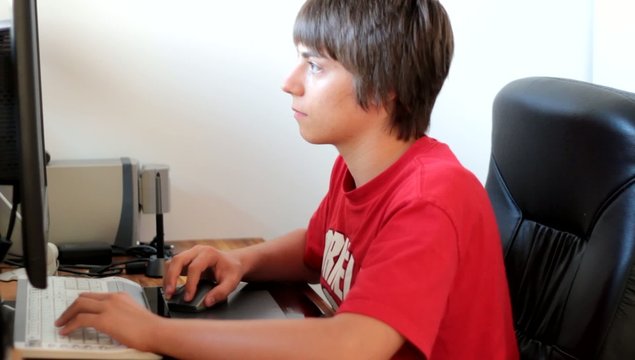 adolescent travaillant devant l'ordianteur