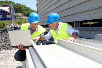 Construction workers checking building material