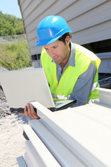 Engineer with laptop computer on building site