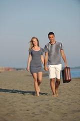 couple on beach with travel bag