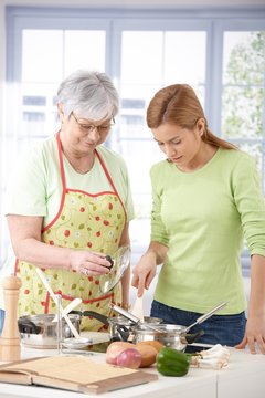 Senior mother and daughter cooking together