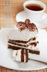 Tea and a slice of cake with cream