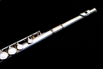 Silver flute on a black background