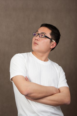 portrait of a young asian man in a white t-shirt with crossed ar